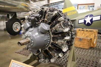 A large engine on display in an airplane hangar.